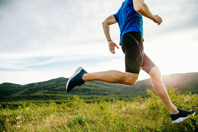 Low section of man running on hill