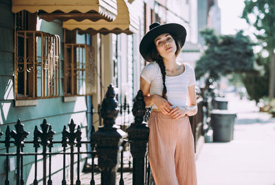 Portrait of woman standing against wall