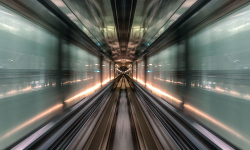 Blurred motion of train at illuminated railroad station