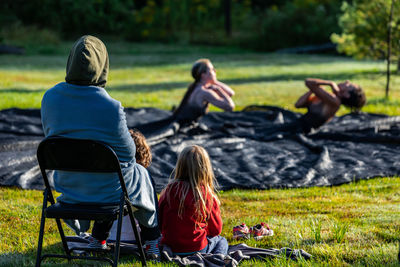 Rear view of people sitting on grass