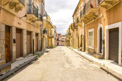 Empty road amidst buildings in town