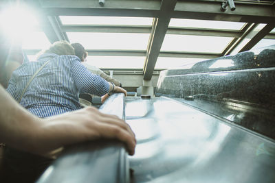 Rear view of people climbing the escalators