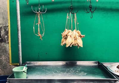 Close-up of chicken hanging on bar 