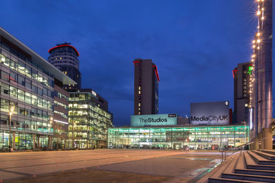 Illuminated buildings against sky at night