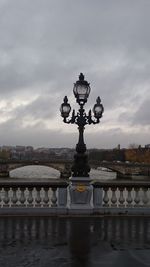 Statue by cityscape against sky