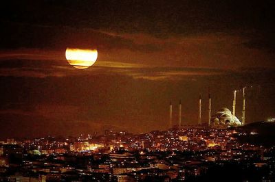 Illuminated city against sky at night