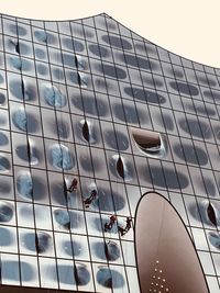 Low angle view of modern glass building against sky