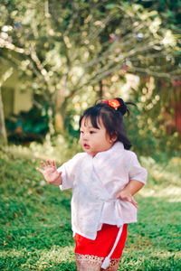 Portrait of cute girl standing on field