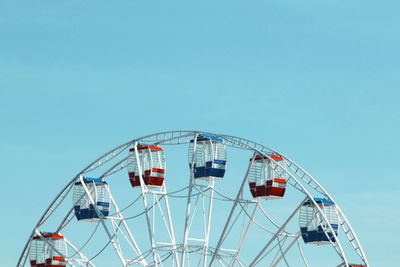 Low angle view of ferris wheel against clear blue sky