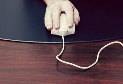 Close-up of hand using mobile phone on table