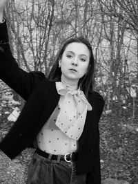 Portrait of woman standing against tree