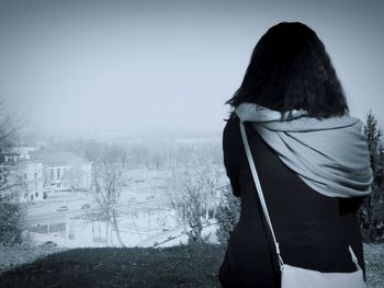 Rear view of woman standing by railing