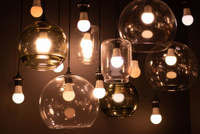Close-up of illuminated light bulb hanging on table
