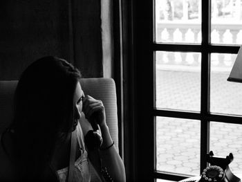 Woman talking on telephone at home