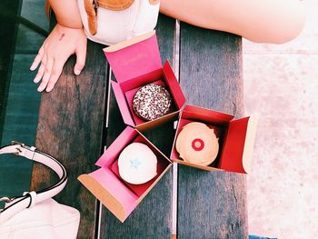 High angle view of woman sitting by donuts on table