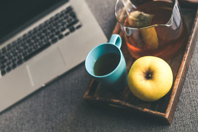 Still life of a natural breakfast at home beside a laptop on the sofa. tea, coffee on a wooden tray 