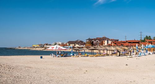 Buildings on beach against clear blue sky