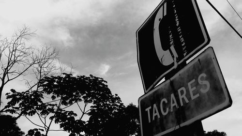 Low angle view of road sign against sky