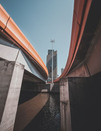 Low angle view of bridge and buildings against clear sky