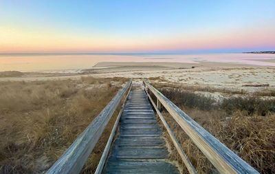 Railroad tracks against clear sky during sunset