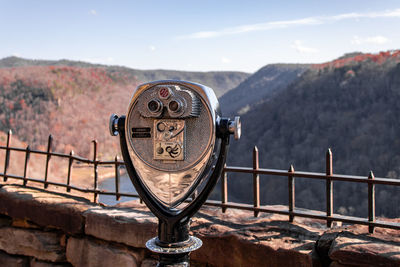 Close-up of coin-operated binoculars against sky