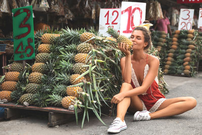 Portrait of young woman holding pineapple