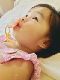 Close-up of cute baby lying on bed