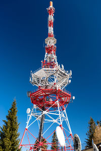 Steel transmission tower of cellular telecommunications network in white and red color 
