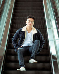Portrait of young man sitting on staircase