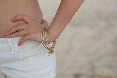 Midsection of woman standing at beach