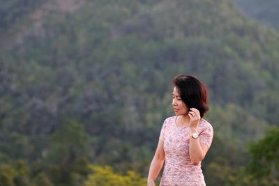 Woman standing against trees