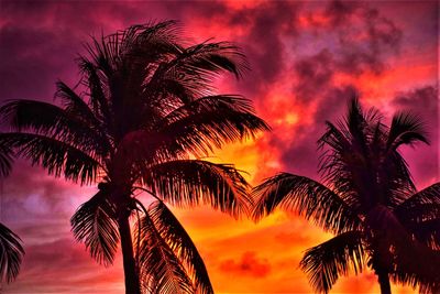 Low angle view of silhouette palm trees against romantic sky