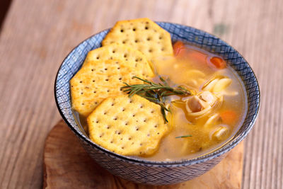 High angle view of soup with crackers on wooden table