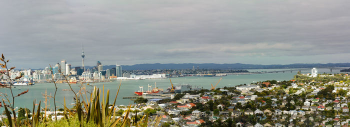 Sailboats in sea against cloudy sky