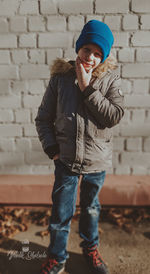 Full length of boy standing against wall