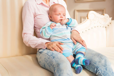 High angle view of cute baby boy lying on bed at home