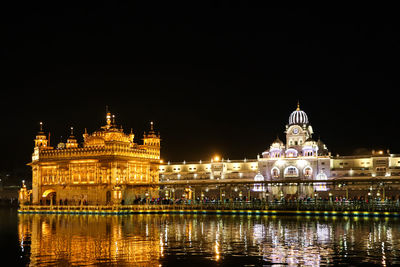 Illuminated building against sky at night