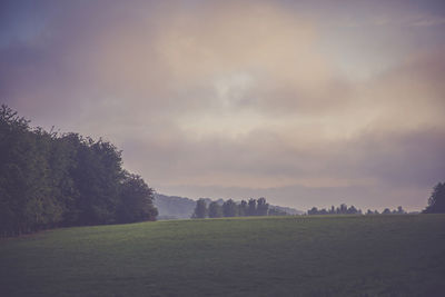 Scenic view of field against sky at sunset