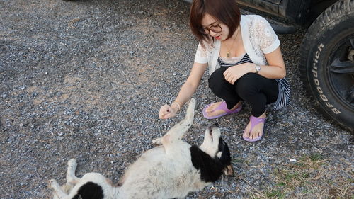 High angle view of woman playing with dog