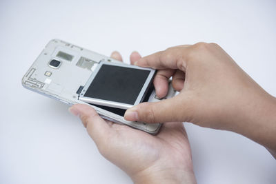 Midsection of man using mobile phone against white background