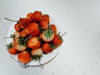 High angle view of strawberries on table against white background