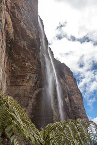 Low angle view of waterfall against sky