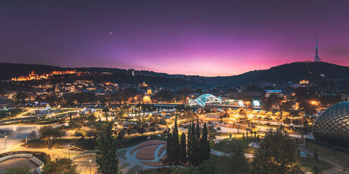 High angle view of illuminated cityscape against sky during sunset