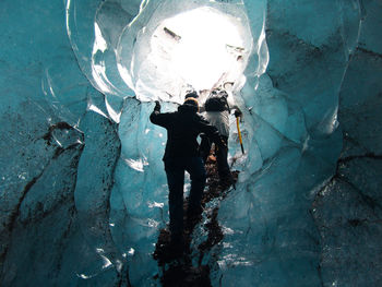 Rear view of people standing in tunnel