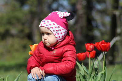 Cute girl sitting on pink flowering plant