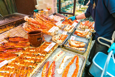 Midsection of man buying seafood at market