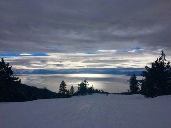 Scenic view of snow covered landscape against dramatic sky