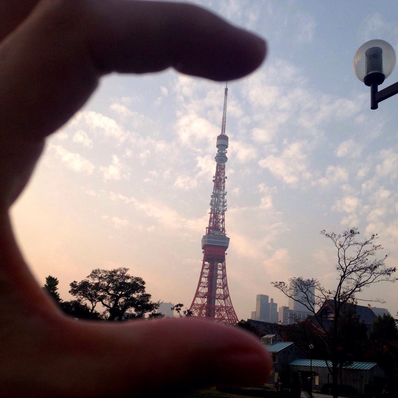 sky, tower, tall - high, low angle view, communications tower, built structure, architecture, cloud - sky, famous place, travel destinations, tree, tourism, international landmark, eiffel tower, communication, cloudy, capital cities, building exterior, person