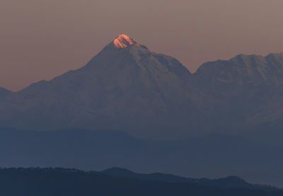 Scenic view of snowcapped mountains against sky during sunset