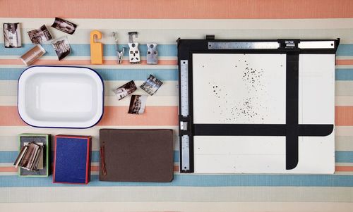 Directly above shot of photographs and equipment on table